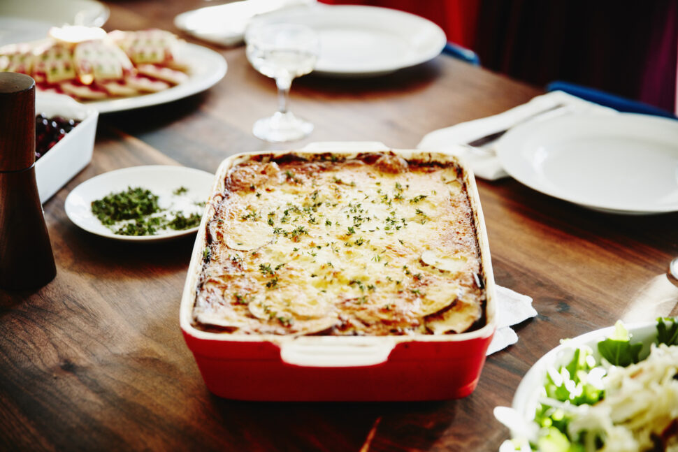 Roasted scalloped potatoes in pan on table.