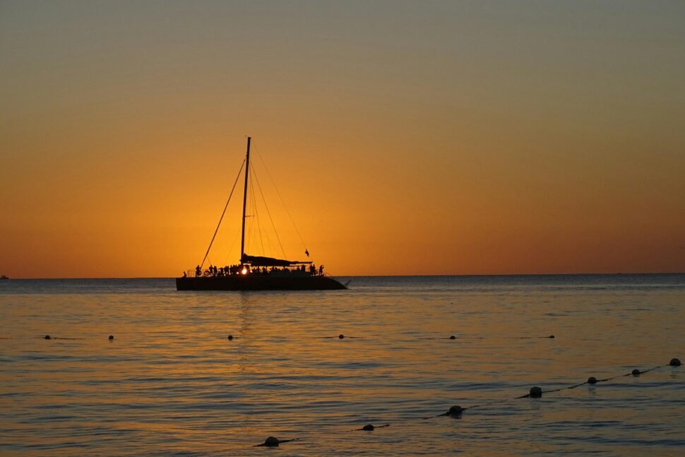 Silhouette of a Sailing Boat on the Sea during Sunset