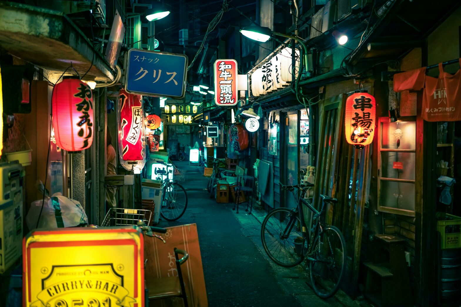 Tokyo alleyway at night glowing with shops.