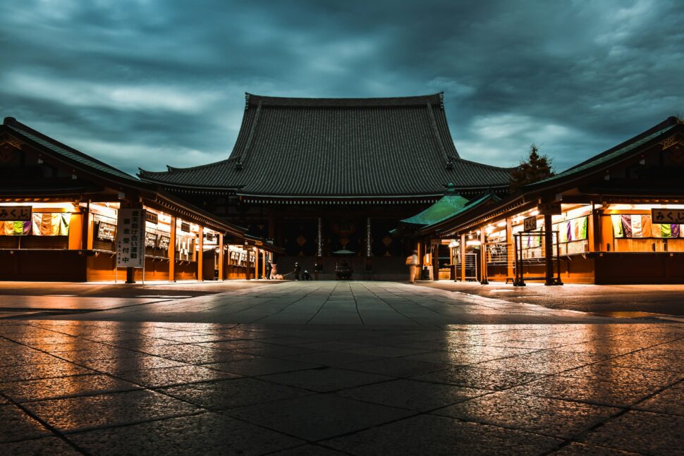 Japanese temple lit with the under glow of its shops.