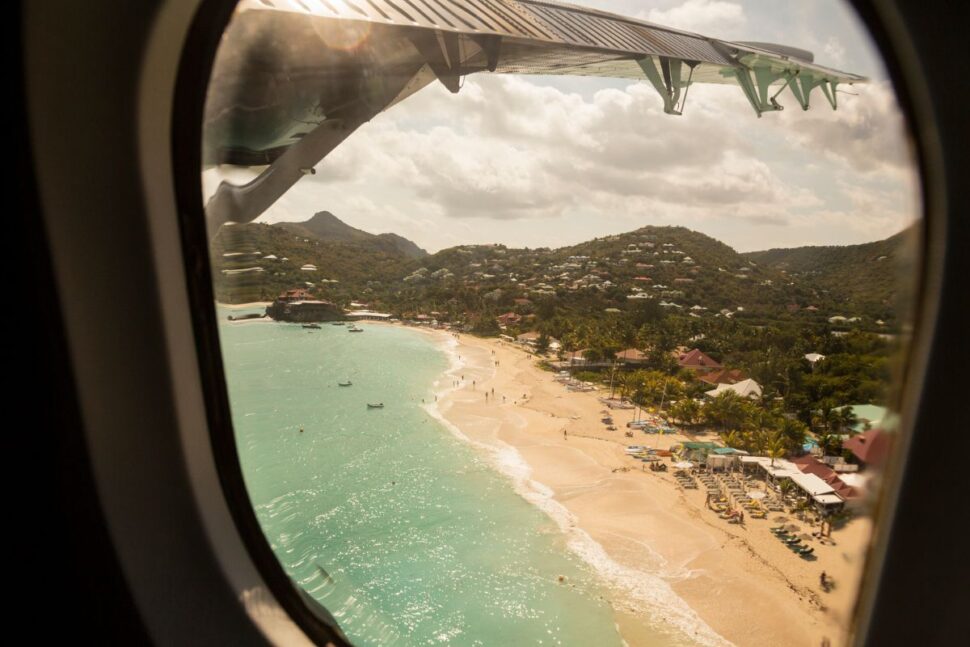 view of Caribbean beach from airplane window