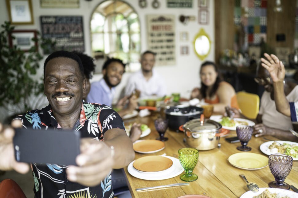 Man taking a selfie of his family during lunch.