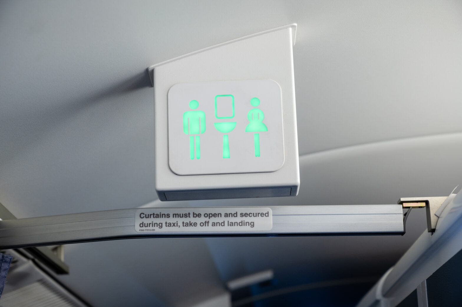 Lavatory / toilet sign on a commercial aircraft. Sign is green indicating that cabin is empty and available for use.