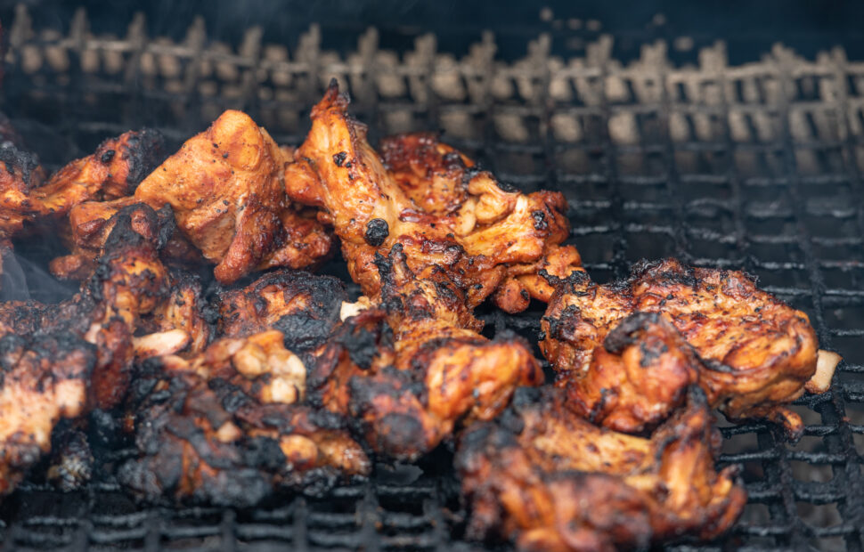 Jerk chicken cooking in a traditional oil drum barbecue