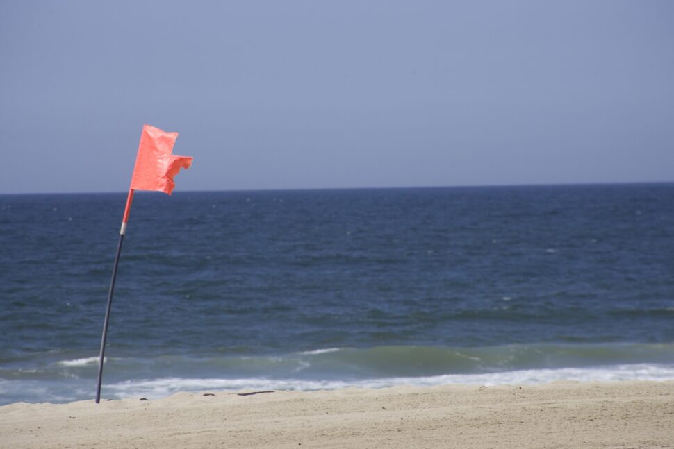 Red warning flag on a beach.