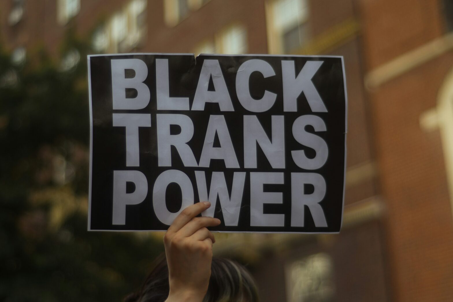 hand holding up 'Black Trans Power' sign