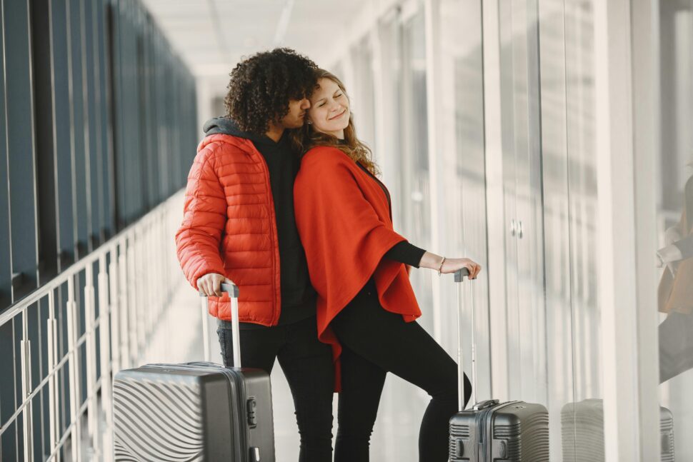 Close-Up Shot of an interracial Couple Holding Luggages